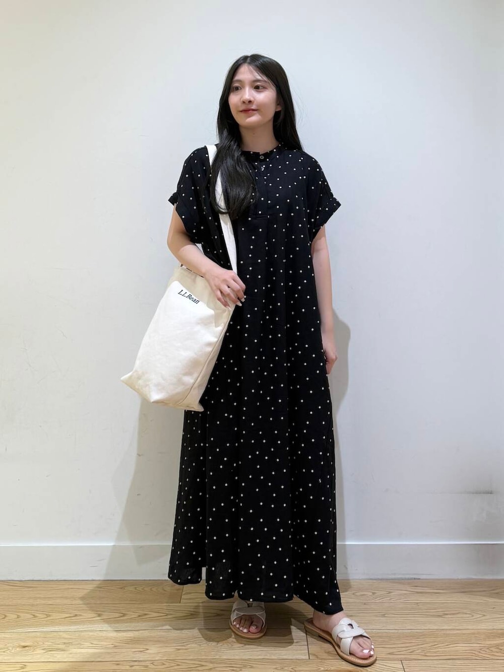 ホワイト系のサンダル、ブラック系のワンピースを着用したレディースの夏コーディネートの3枚目の写真