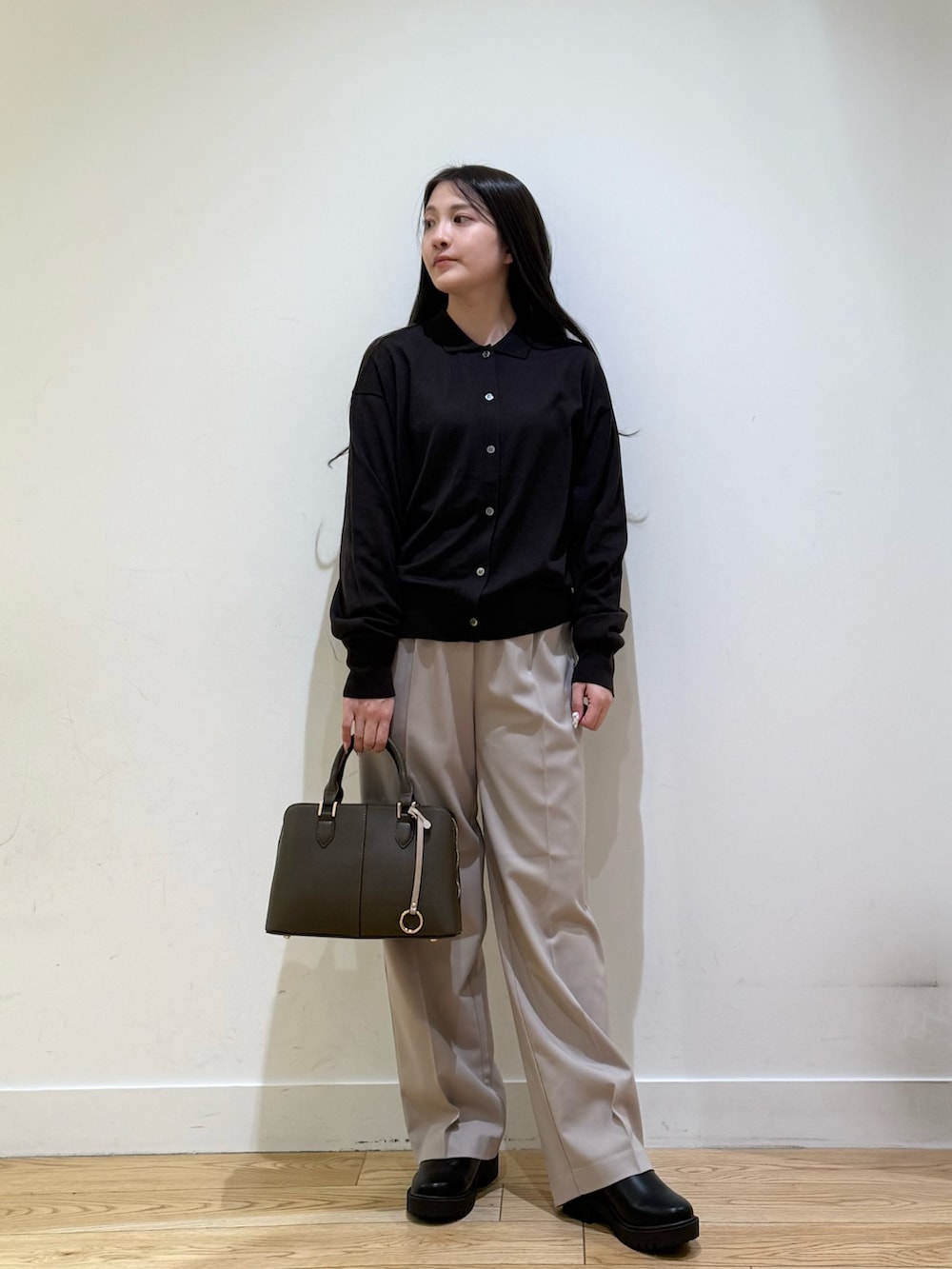 グレー系のステンカラーコート、パープル系のハンドバッグ、ベージュ系のその他パンツを着用したレディースの秋コーディネートの7枚目の写真