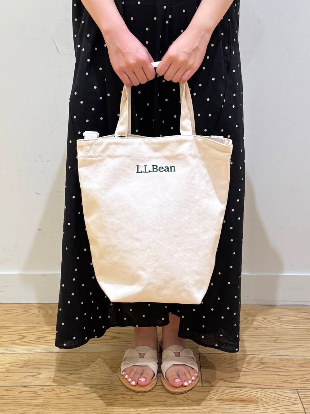 ホワイト系のサンダル、ブラック系のワンピースを着用したレディースの夏コーディネートの6枚目の写真