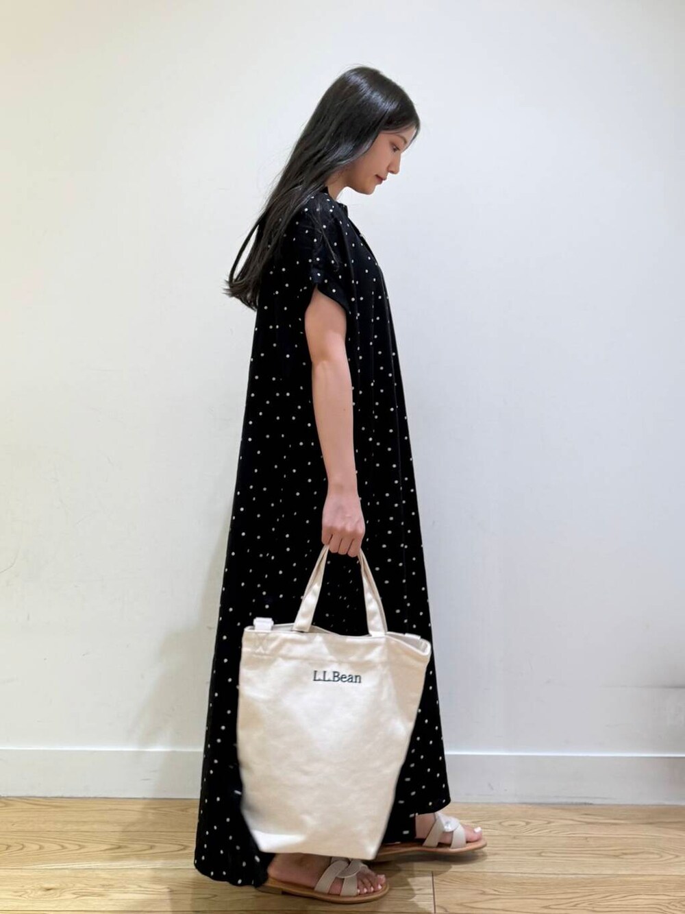 ホワイト系のサンダル、ブラック系のワンピースを着用したレディースの夏コーディネートの4枚目の写真