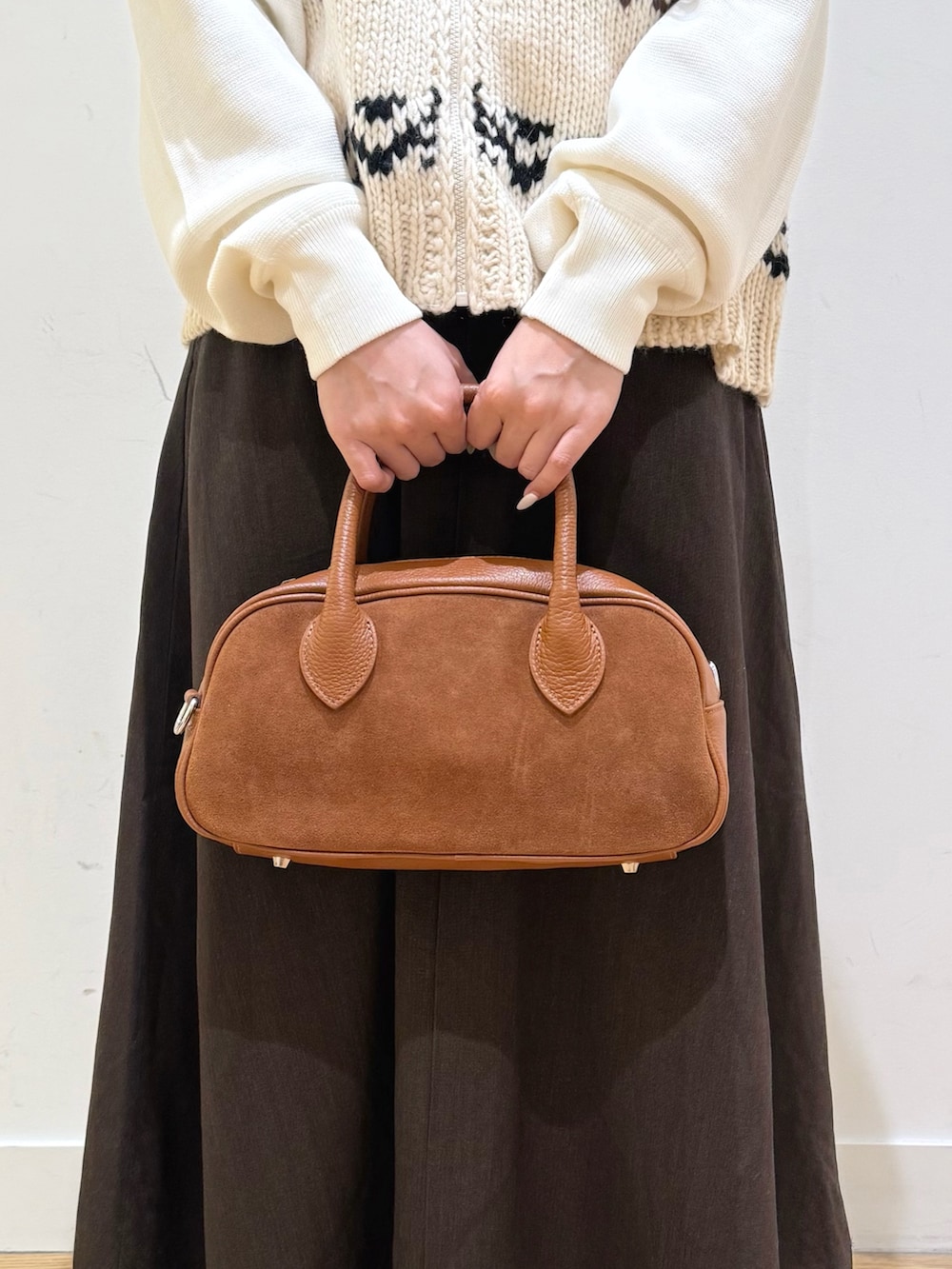 ホワイト系のベスト、ホワイト系のニット/セーター、ブラウン系のスカートを着用したレディースの秋コーディネートの7枚目の写真