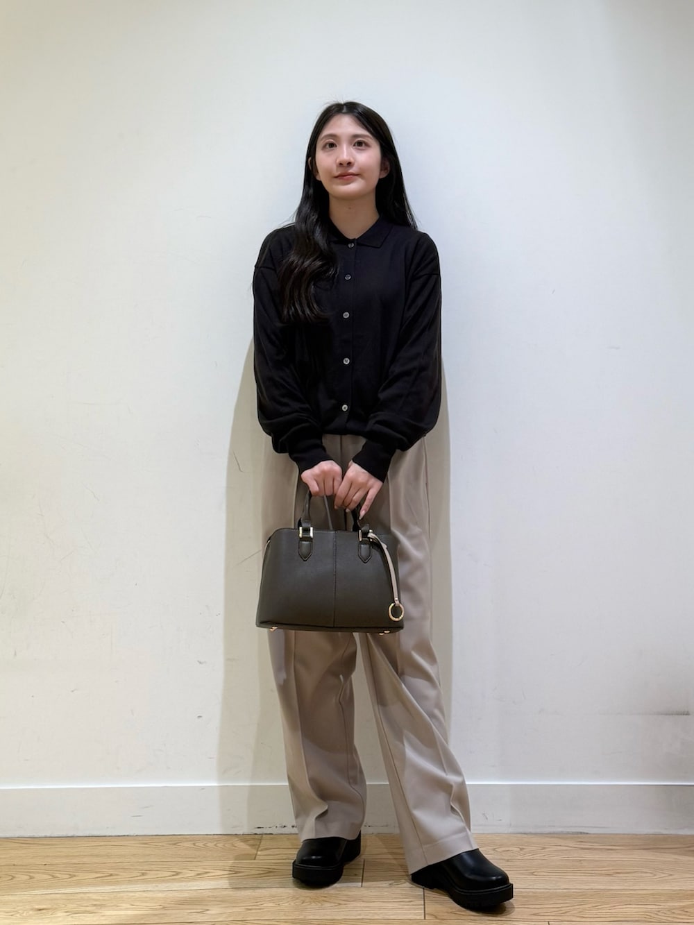 グレー系のステンカラーコート、パープル系のハンドバッグ、ベージュ系のその他パンツを着用したレディースの秋コーディネートの5枚目の写真