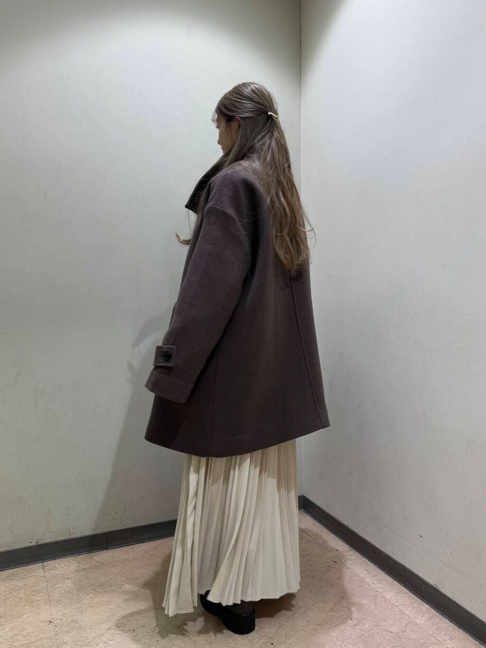 ブラック系のボストンバッグ、ブラウン系のブーツ、ブラウン系のその他アウターを着用したレディースの冬コーディネートの3枚目の写真