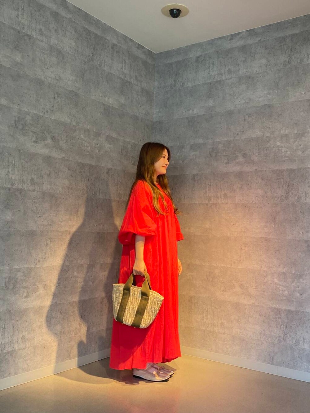 ベージュ系のかごバッグ、ホワイト系のワンピース、レッド系のワンピースを着用したレディースの夏コーディネートの3枚目の写真