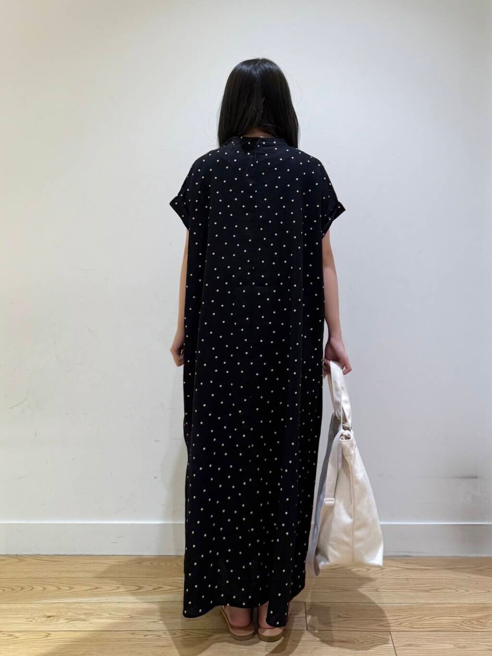 ホワイト系のサンダル、ブラック系のワンピースを着用したレディースの夏コーディネートの5枚目の写真