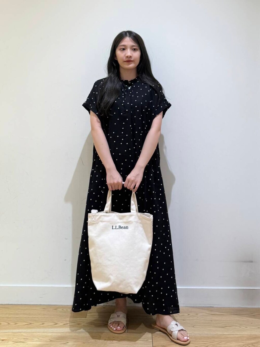 ホワイト系のサンダル、ブラック系のワンピースを着用したレディースの夏コーディネートの2枚目の写真