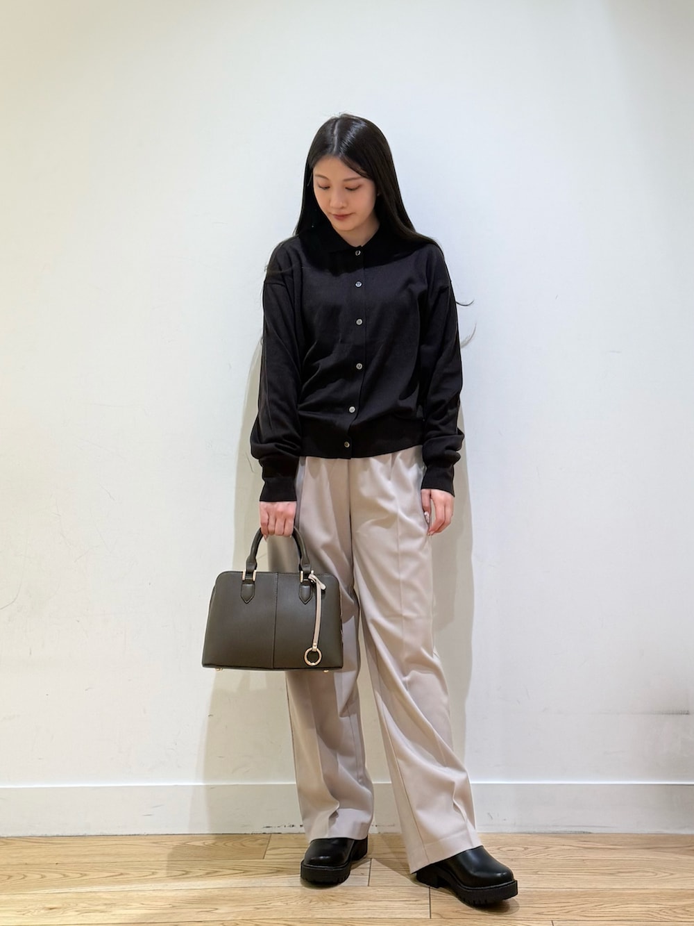 グレー系のステンカラーコート、パープル系のハンドバッグ、ベージュ系のその他パンツを着用したレディースの秋コーディネートの6枚目の写真