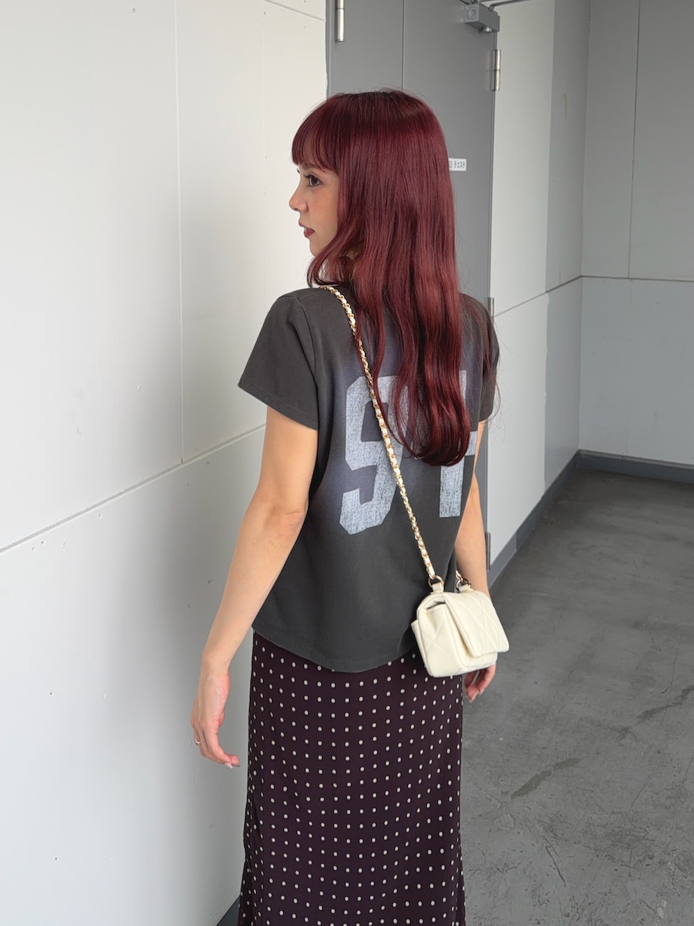 グリーン系のTシャツ/カットソー、ブラウン系のスカート、ホワイト系のショルダーバッグを着用したレディースの夏コーディネートの5枚目の写真