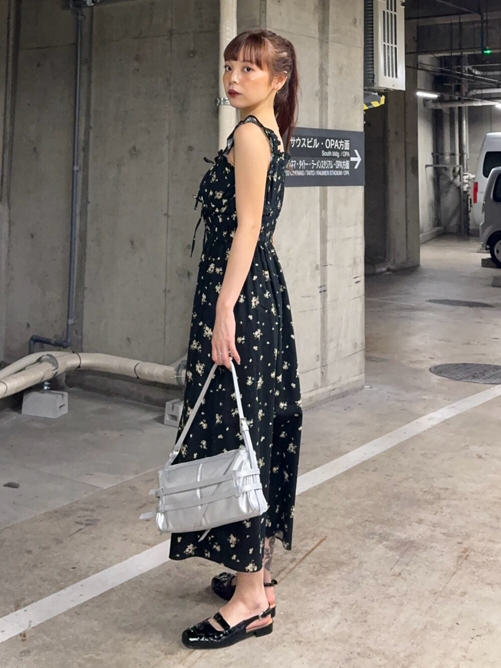 ブラック系のワンピース、シルバー系のショルダーバッグ、ブラック系のサンダルを着用したレディースの夏コーディネートの2枚目の写真