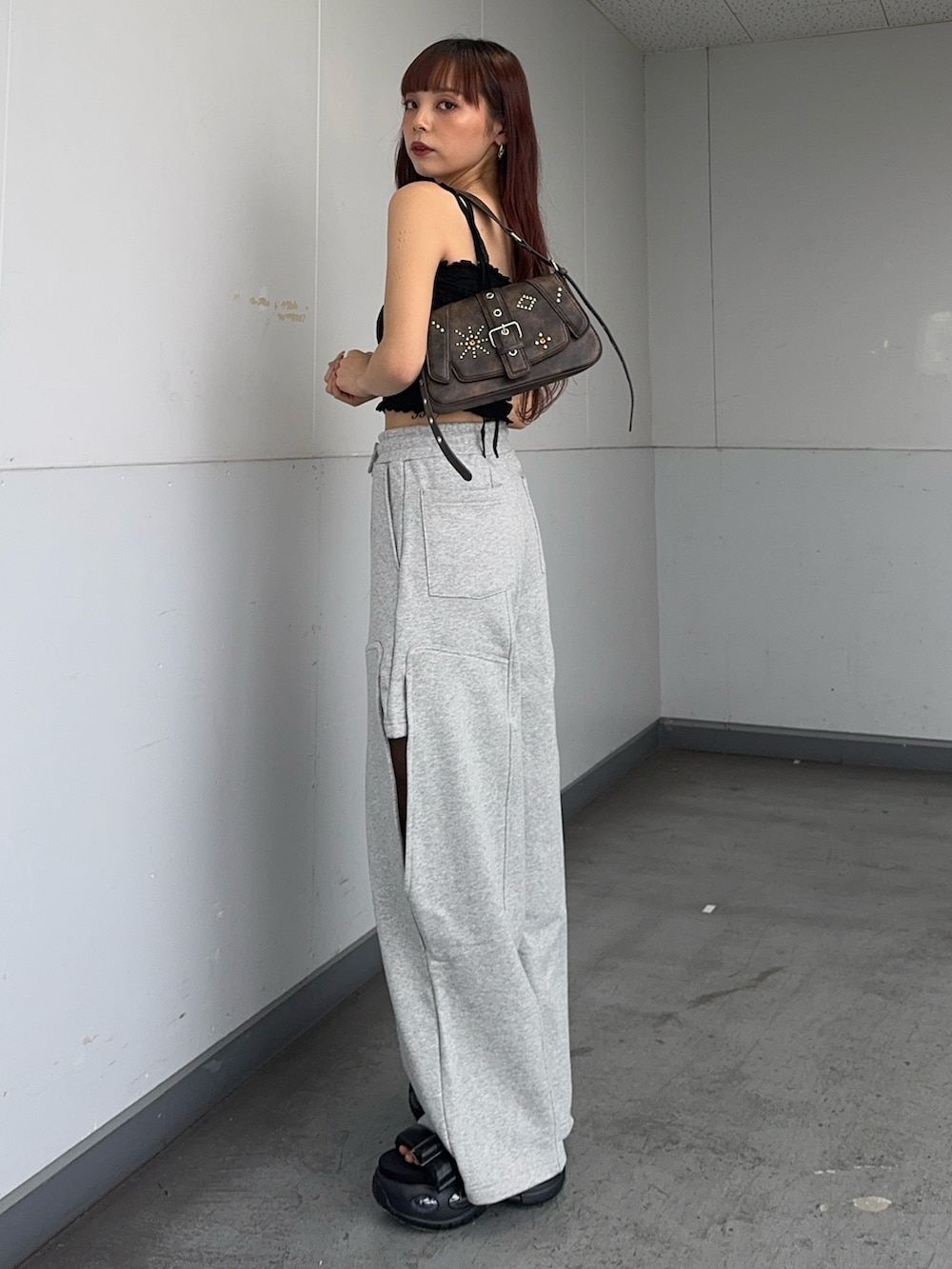 ブラック系のキャミソール、ブラウン系のハンドバッグ、ブラック系のサンダルを着用したレディースの夏コーディネートの2枚目の写真