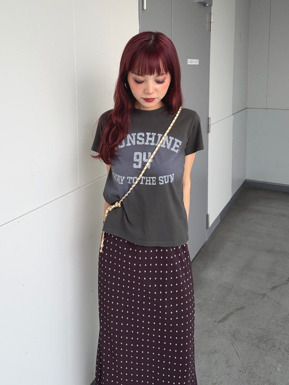 グリーン系のTシャツ/カットソー、ブラウン系のスカート、ホワイト系のショルダーバッグを着用したレディースの夏コーディネートの4枚目の写真