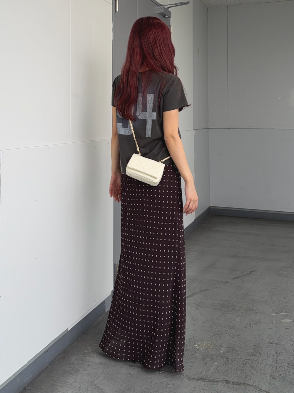 グリーン系のTシャツ/カットソー、ブラウン系のスカート、ホワイト系のショルダーバッグを着用したレディースの夏コーディネートの3枚目の写真