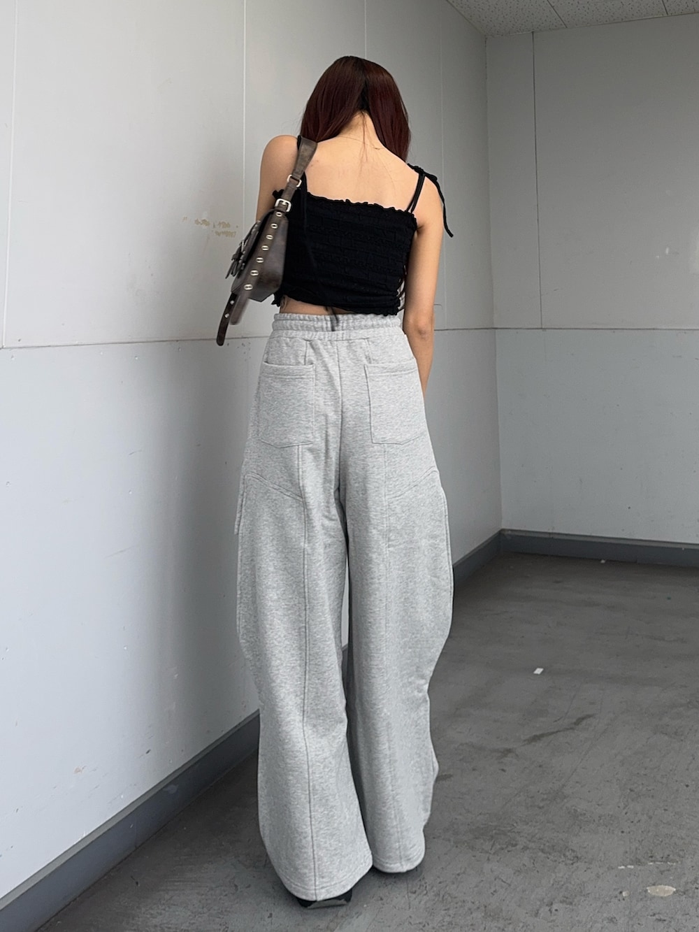 ブラック系のキャミソール、ブラウン系のハンドバッグ、ブラック系のサンダルを着用したレディースの夏コーディネートの3枚目の写真