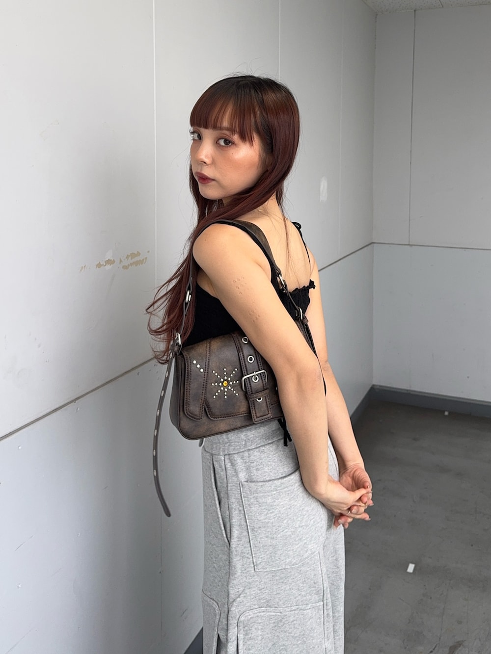 ブラック系のキャミソール、ブラウン系のハンドバッグ、ブラック系のサンダルを着用したレディースの夏コーディネートの5枚目の写真