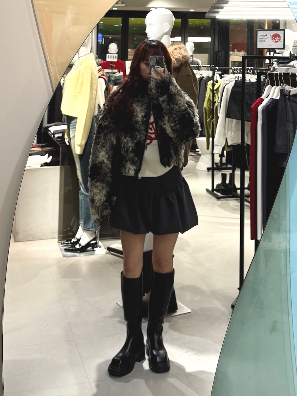 ブラック系のブルゾン、ホワイト系のニット/セーター、グレー系のスカートを着用したレディースの秋コーディネートの2枚目の写真