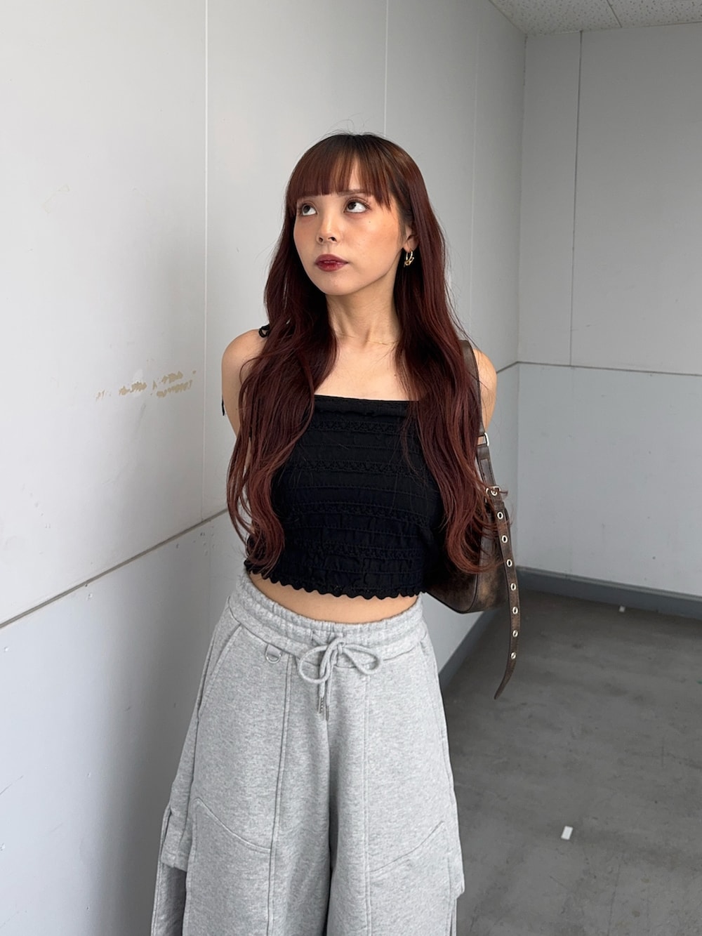 ブラック系のキャミソール、ブラウン系のハンドバッグ、ブラック系のサンダルを着用したレディースの夏コーディネートの4枚目の写真