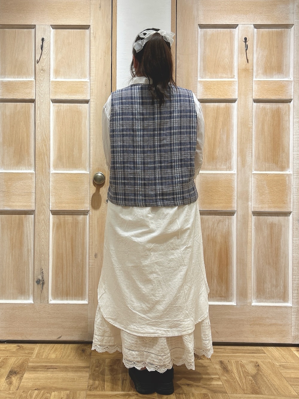 ブルー系のベスト、ホワイト系のワンピース、ホワイト系のスカートを着用したレディースの夏コーディネートの3枚目の写真