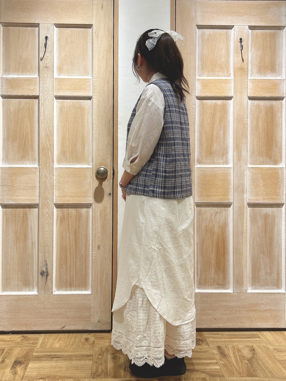 ブルー系のベスト、ホワイト系のワンピース、ホワイト系のスカートを着用したレディースの夏コーディネートの2枚目の写真