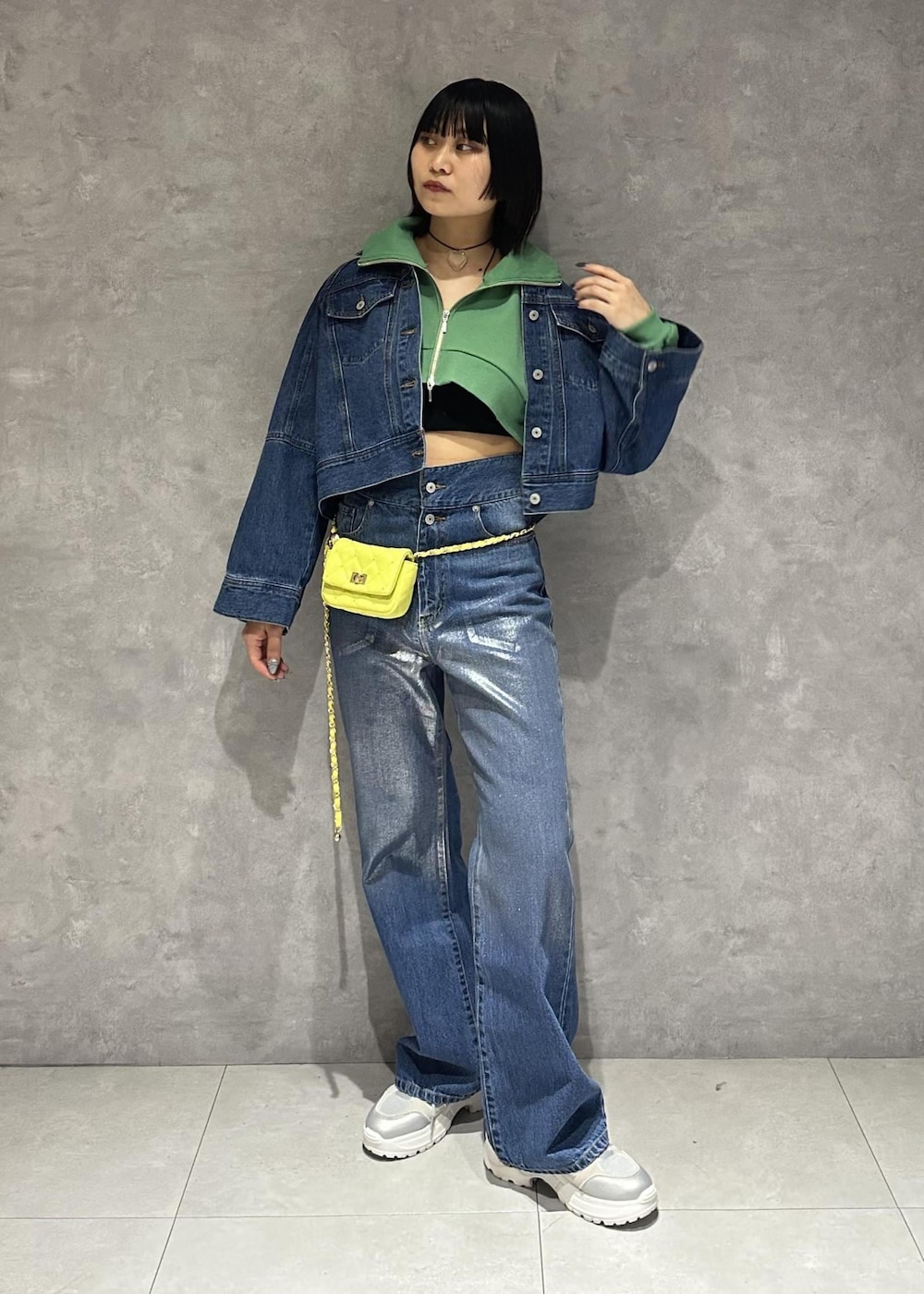 イエロー系のショルダーバッグ、シルバー系のスニーカー、グリーン系のワンピースを着用したレディースの春コーディネートの2枚目の写真