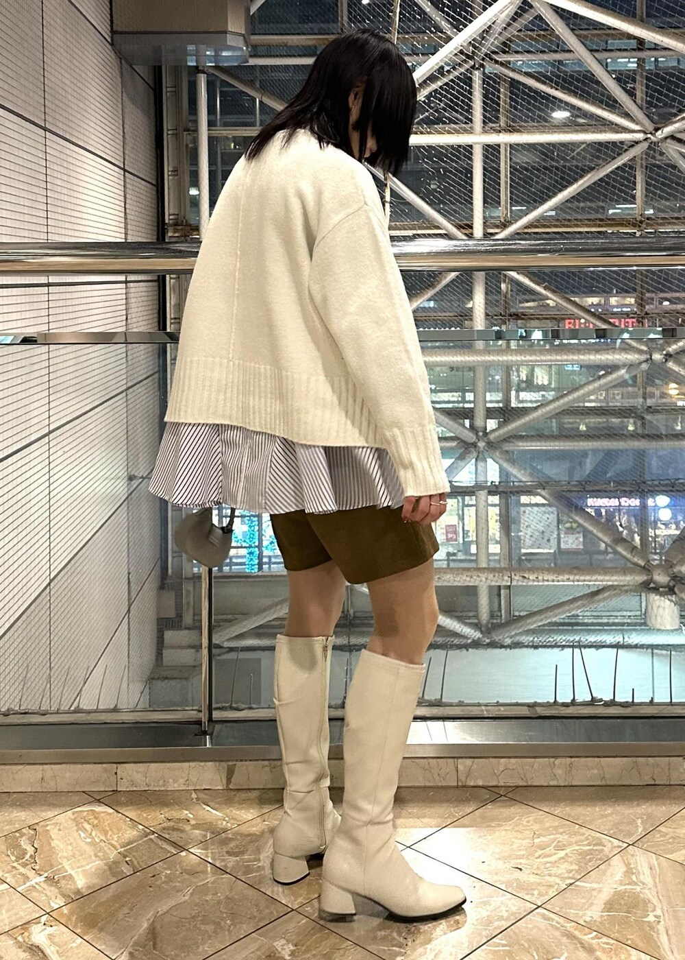 ホワイト系のニット/セーター、ブルー系のシャツ/ブラウス、イエロー系のスラックスを着用したレディースの冬コーディネートの5枚目の写真