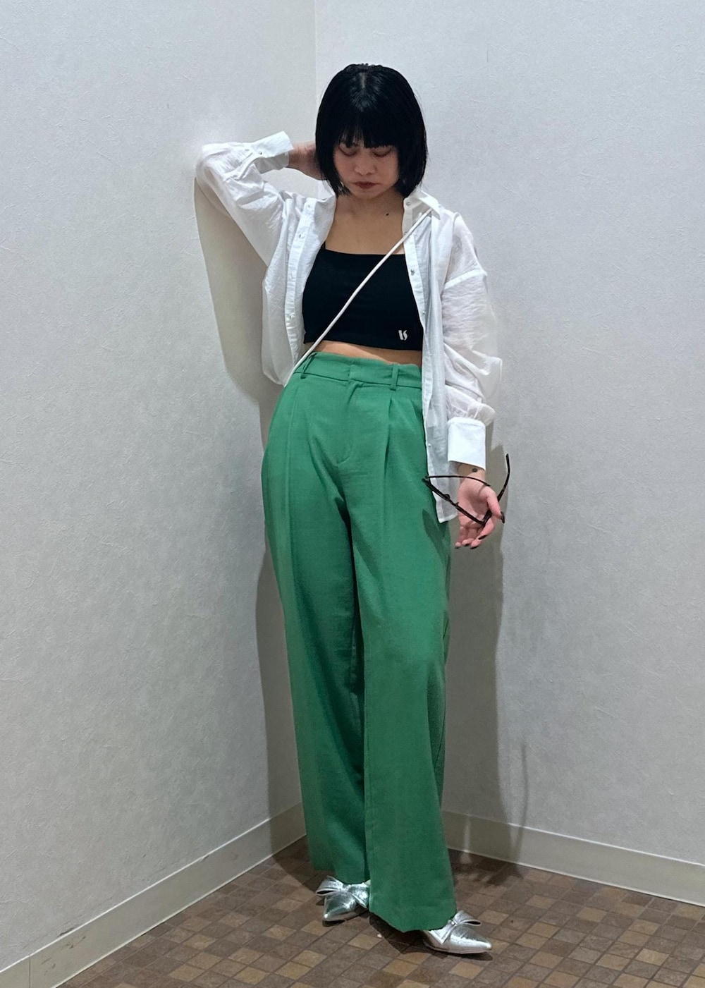 シルバー系のパンプス、ブラック系のキャミソール、グリーン系のスラックスを着用したレディースの夏コーディネートの3枚目の写真