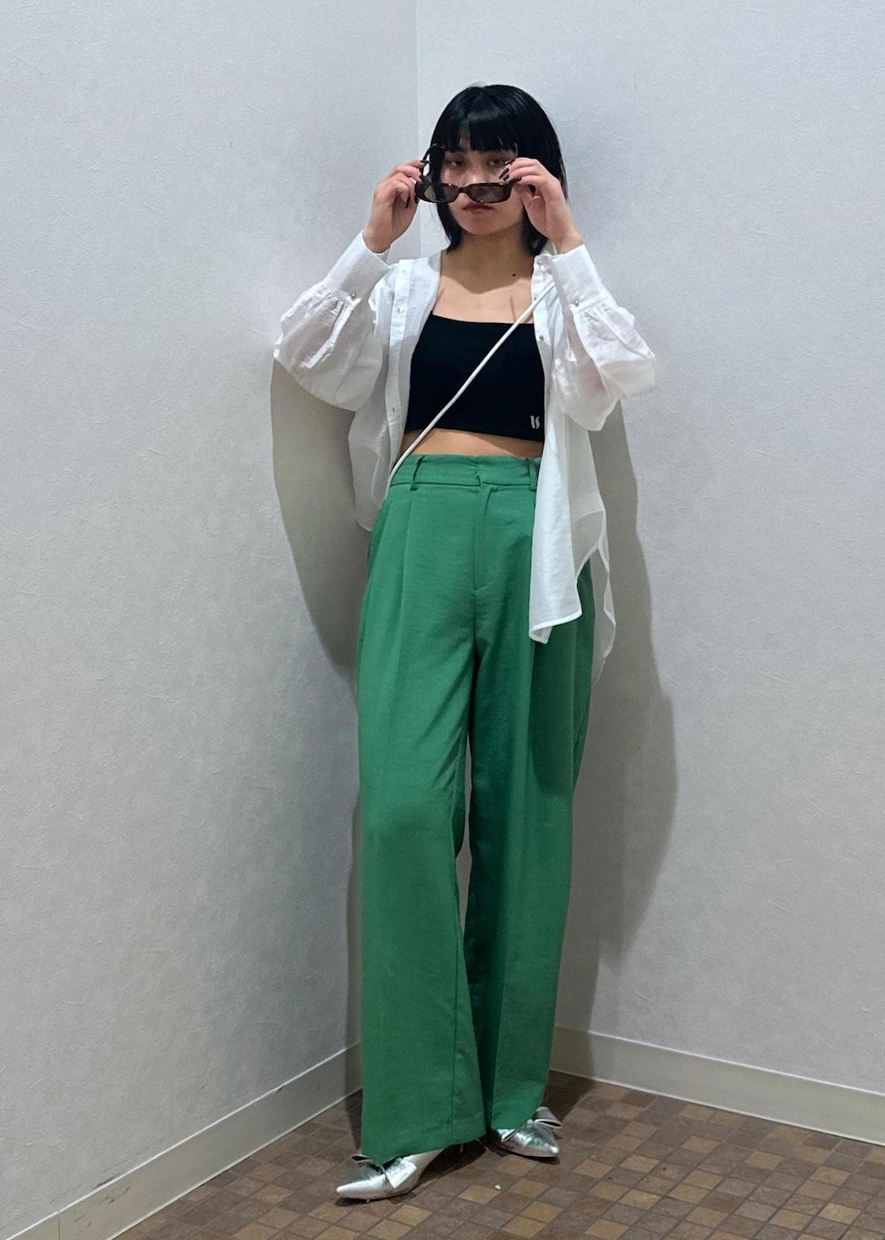 シルバー系のパンプス、ブラック系のキャミソール、グリーン系のスラックスを着用したレディースの夏コーディネートの2枚目の写真