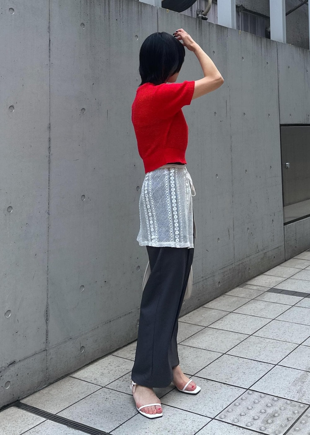 ホワイト系のサンダル、ホワイト系のスカート、レッド系のニット/セーターを着用したレディースの夏コーディネートの3枚目の写真