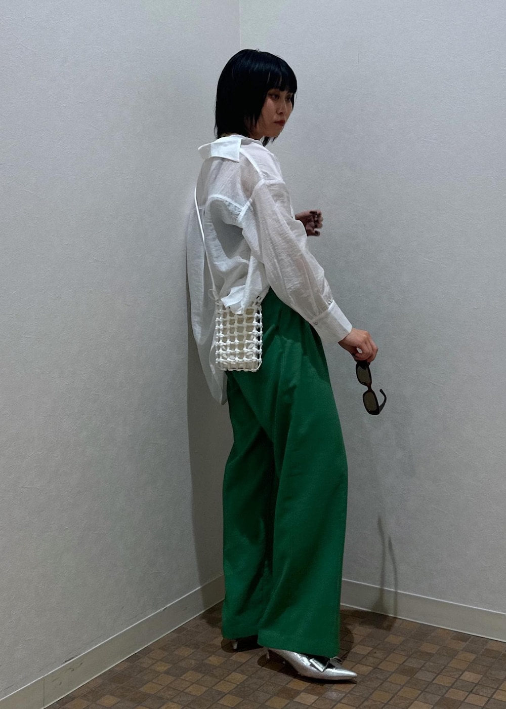 シルバー系のパンプス、ブラック系のキャミソール、グリーン系のスラックスを着用したレディースの夏コーディネートの6枚目の写真