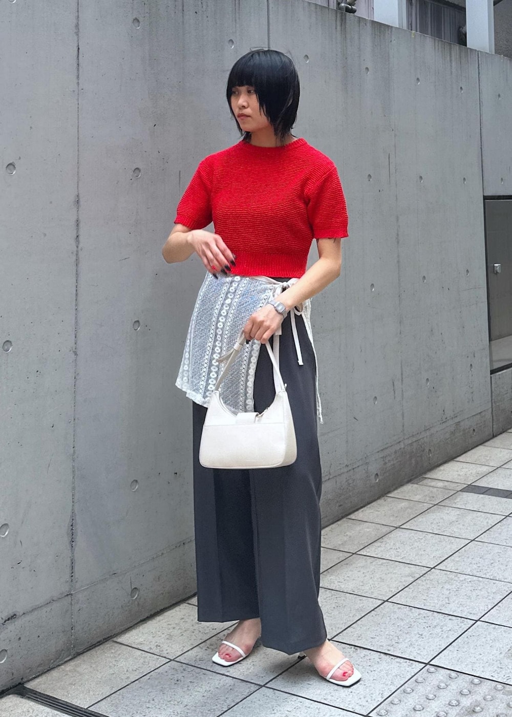 ホワイト系のサンダル、ホワイト系のスカート、レッド系のニット/セーターを着用したレディースの夏コーディネートの2枚目の写真