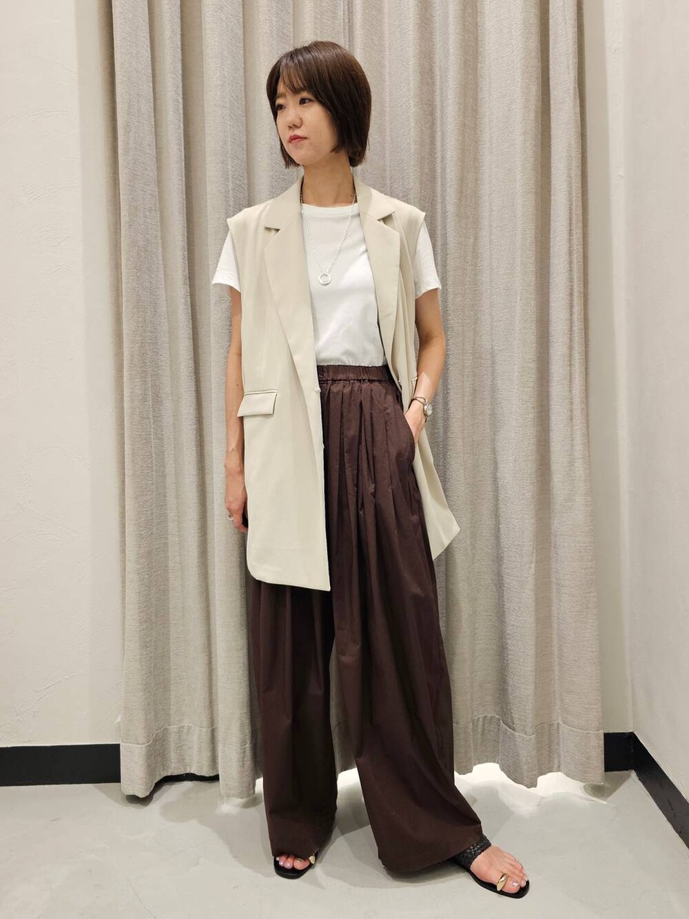 ブラウン系のその他パンツ、ホワイト系のTシャツ/カットソー、ブラック系のサンダルを着用したレディースの夏コーディネートの2枚目の写真