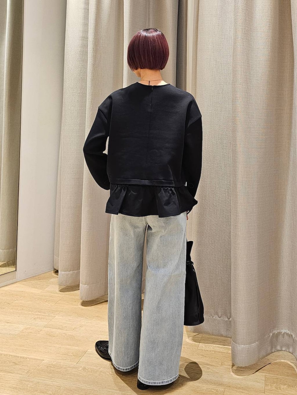 ブルー系のデニムパンツ、ブラック系のTシャツ/カットソー、ブラック系のトートバッグを着用したレディースの冬コーディネートの8枚目の写真