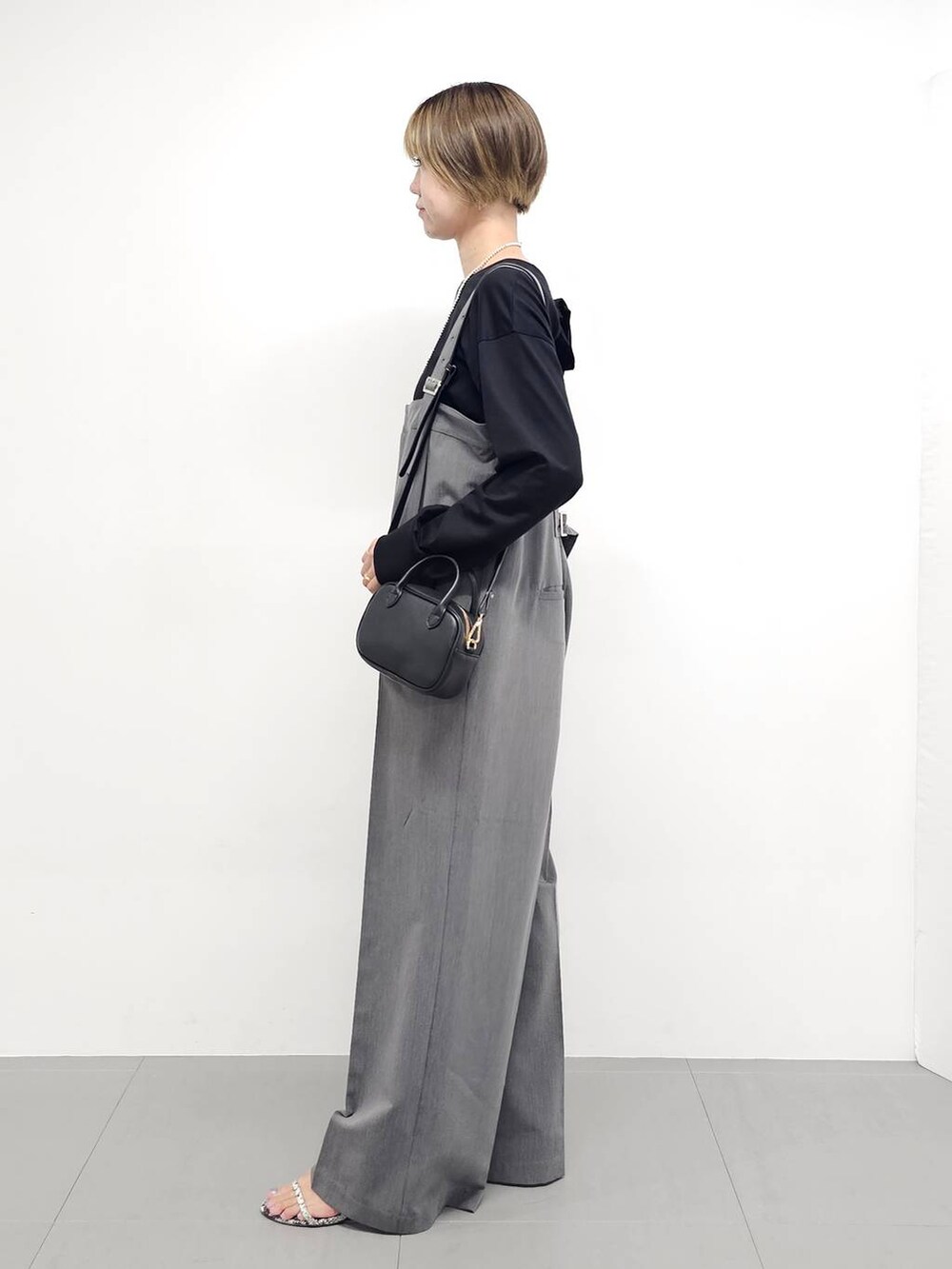 グレー系のサロペット/オーバーオール、その他のサンダル、ブラック系のTシャツ/カットソーを着用したレディースの秋コーディネートの3枚目の写真