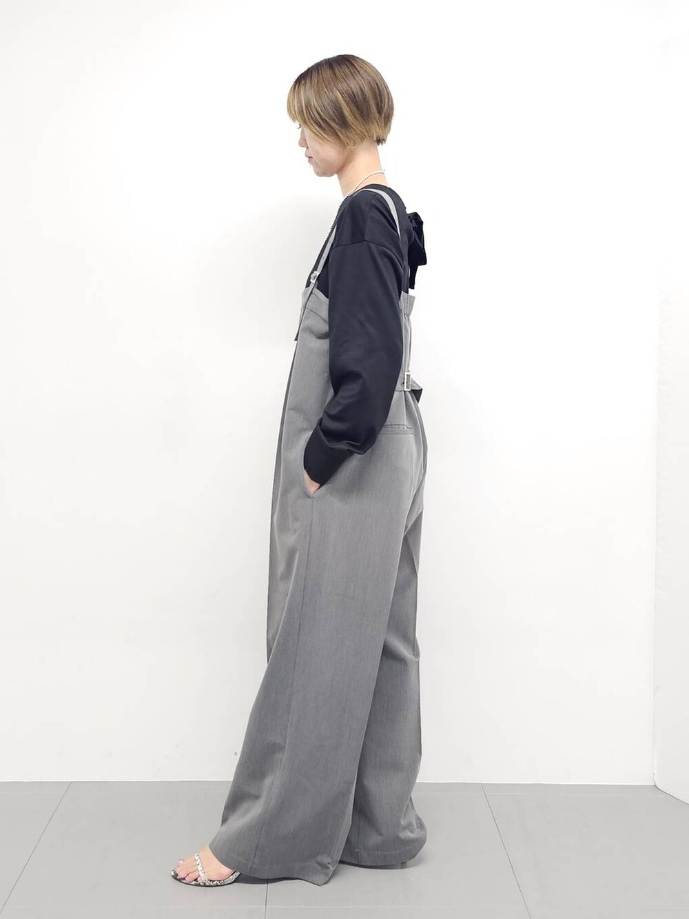 グレー系のサロペット/オーバーオール、その他のサンダル、ブラック系のTシャツ/カットソーを着用したレディースの秋コーディネートの5枚目の写真
