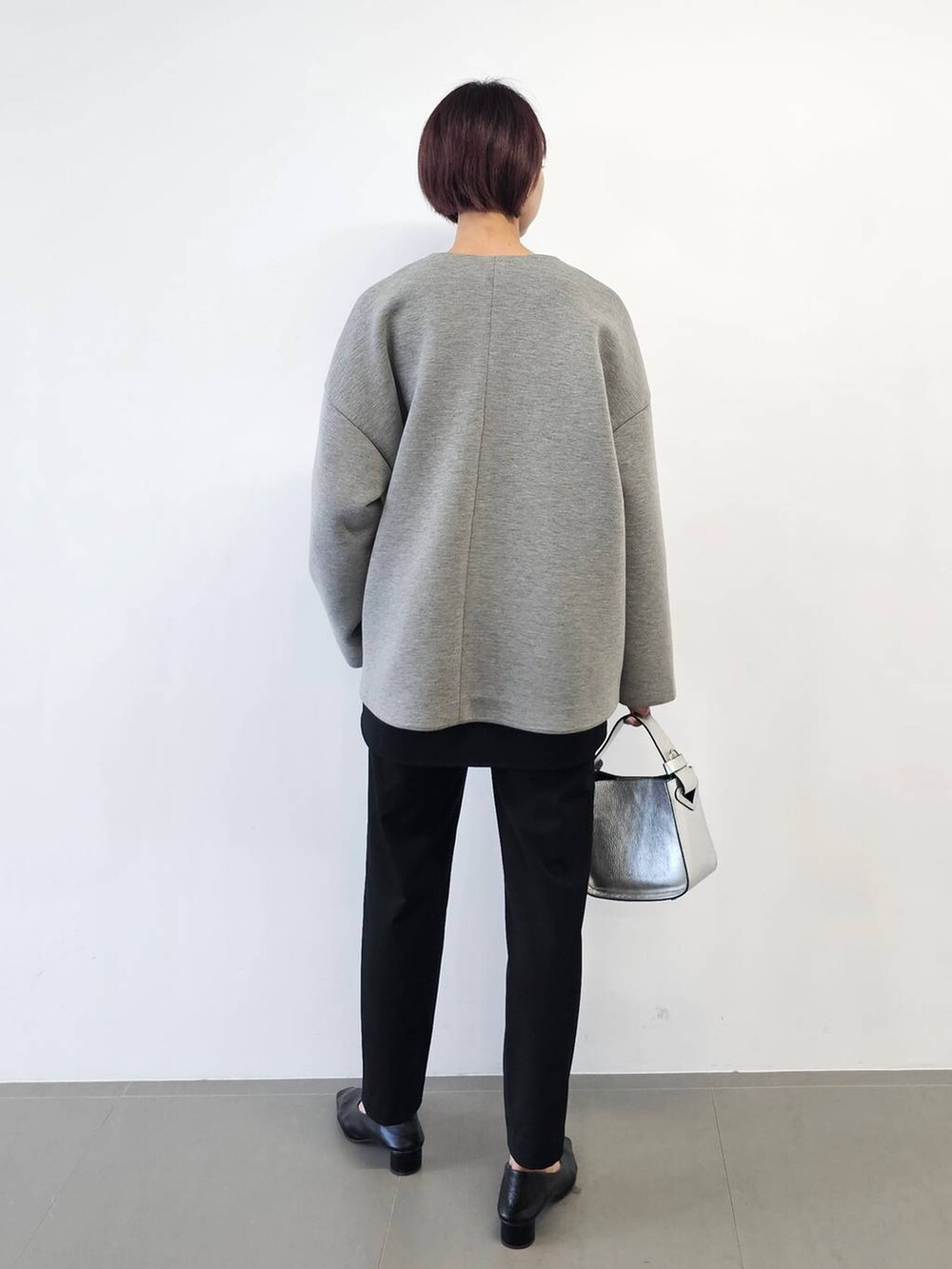 シルバー系のショルダーバッグ、ブラック系のシャツ/ブラウス、ブラック系のパンプスを着用したレディースの冬コーディネートの3枚目の写真