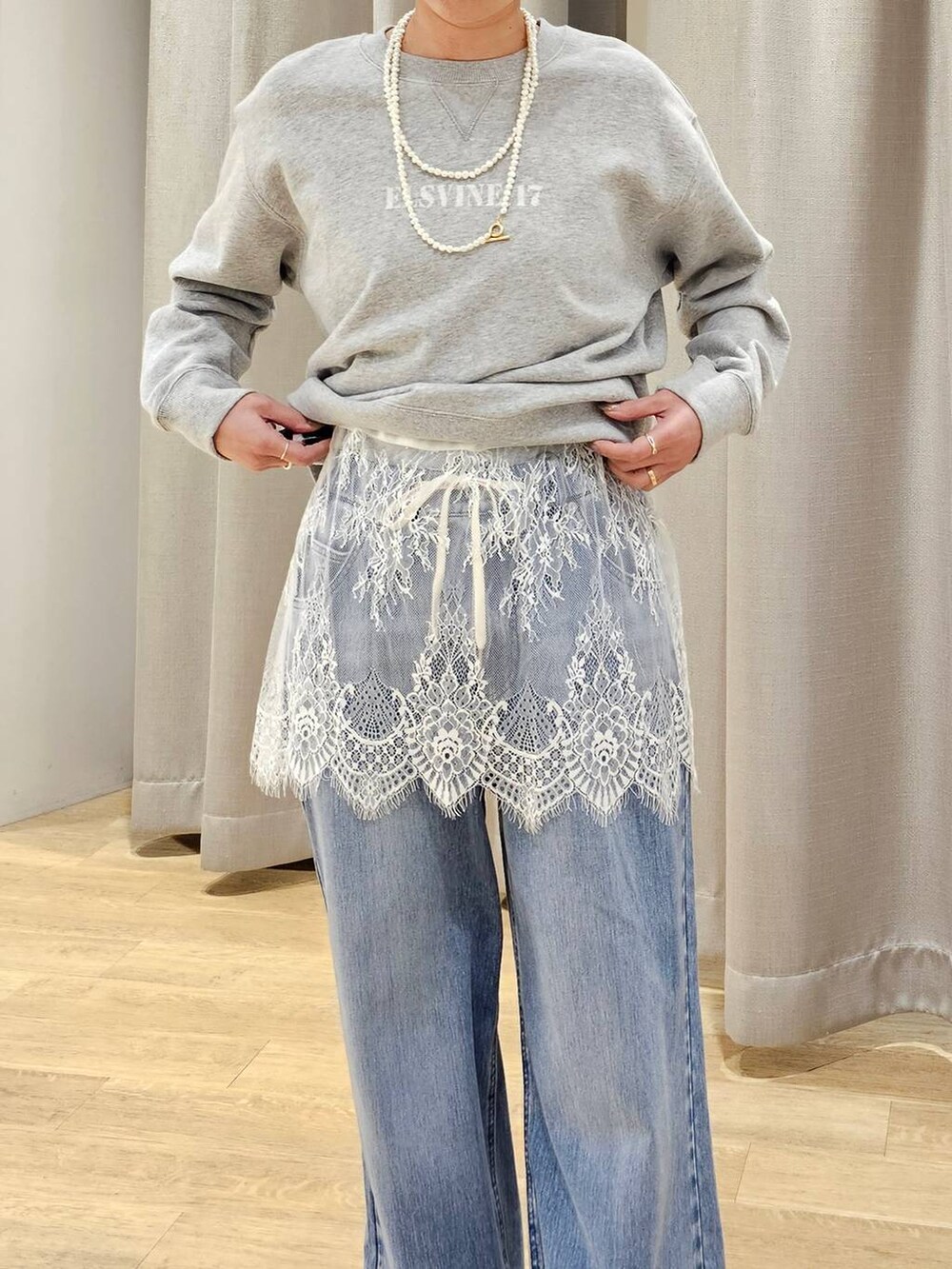 ブルー系のデニムパンツ、グレー系のスウェット、グリーン系のMA-1を着用したレディースの冬コーディネートの5枚目の写真