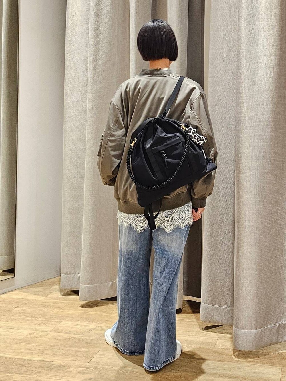 ブルー系のデニムパンツ、グレー系のスウェット、グリーン系のMA-1を着用したレディースの冬コーディネートの3枚目の写真