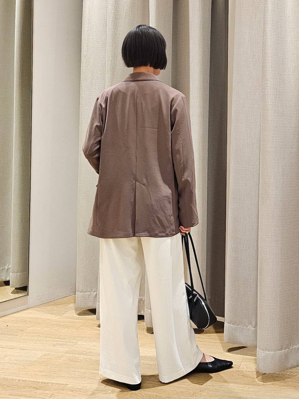 ホワイト系のスラックス、ホワイト系のシャツ/ブラウス、グリーン系のテーラードジャケットを着用したレディースの冬コーディネートの4枚目の写真