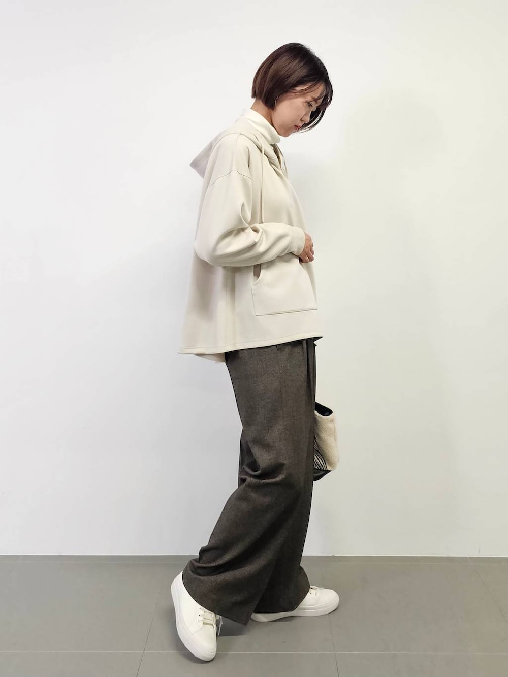 ホワイト系のTシャツ/カットソー、ホワイト系のスニーカー、ホワイト系のトートバッグを着用したレディースの冬コーディネートの2枚目の写真