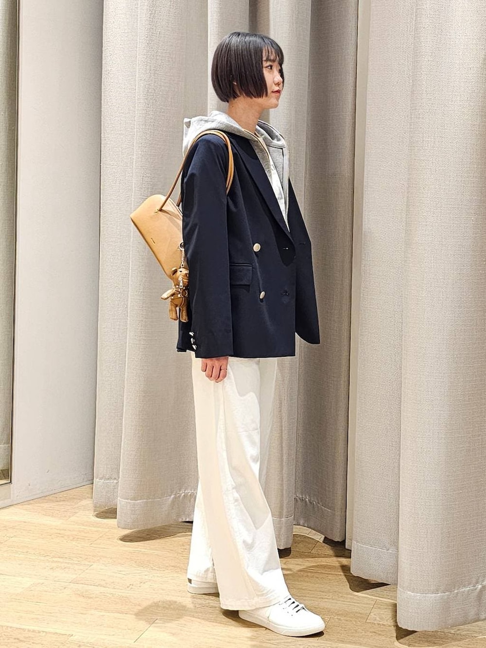 グレー系のパーカー、ホワイト系のTシャツ/カットソー、ブルー系のテーラードジャケットを着用したレディースの冬コーディネートの3枚目の写真