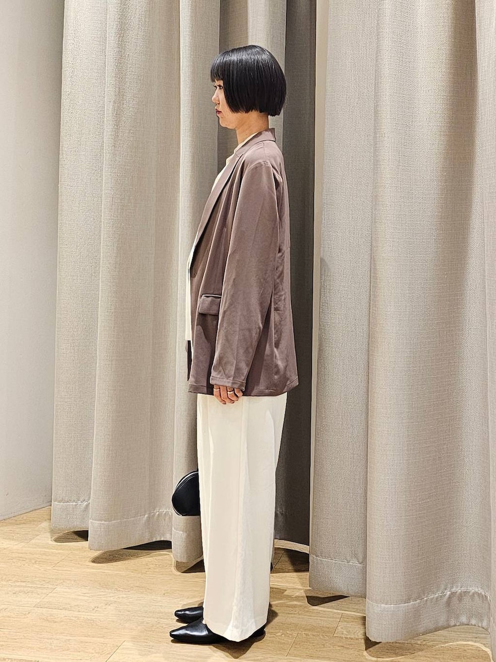 ホワイト系のスラックス、ホワイト系のシャツ/ブラウス、グリーン系のテーラードジャケットを着用したレディースの冬コーディネートの3枚目の写真