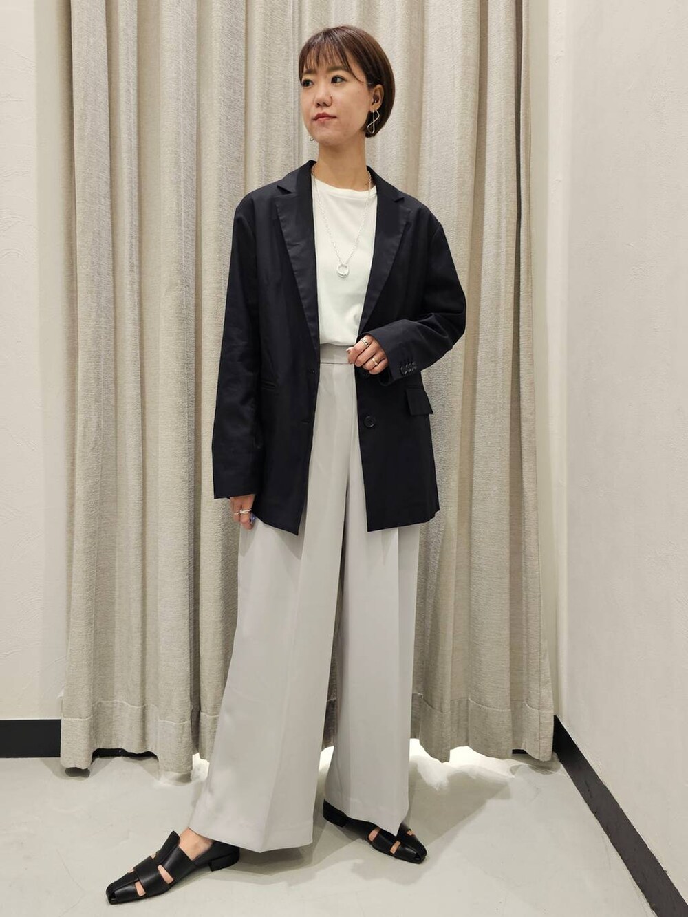 ブラック系のパンプス、ホワイト系のTシャツ/カットソー、グレー系のスラックスを着用したレディースの秋コーディネートの5枚目の写真