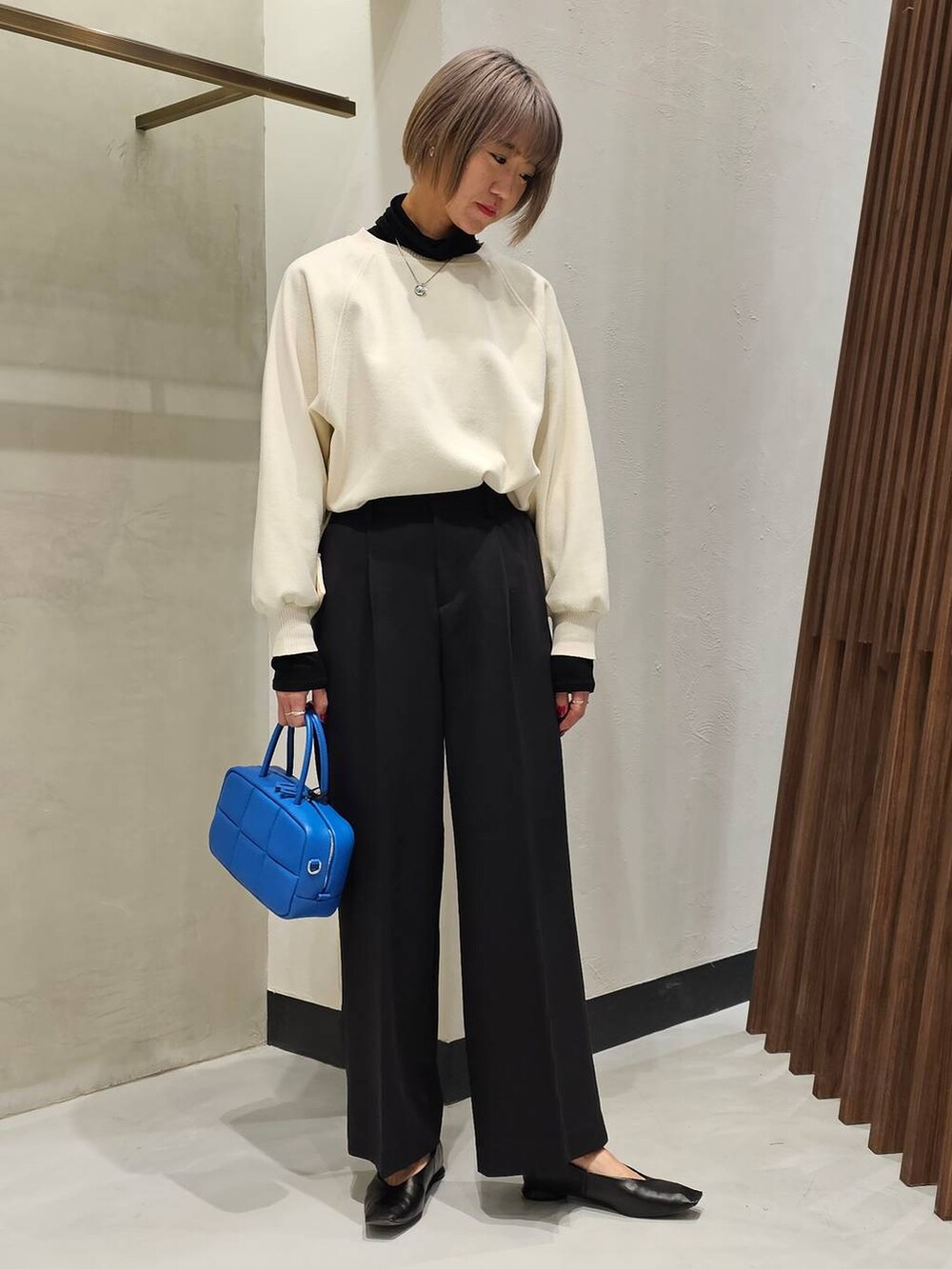 ブラック系のパンプス、ブラック系のTシャツ/カットソー、ホワイト系のニット/セーターを着用したレディースの冬コーディネートの5枚目の写真