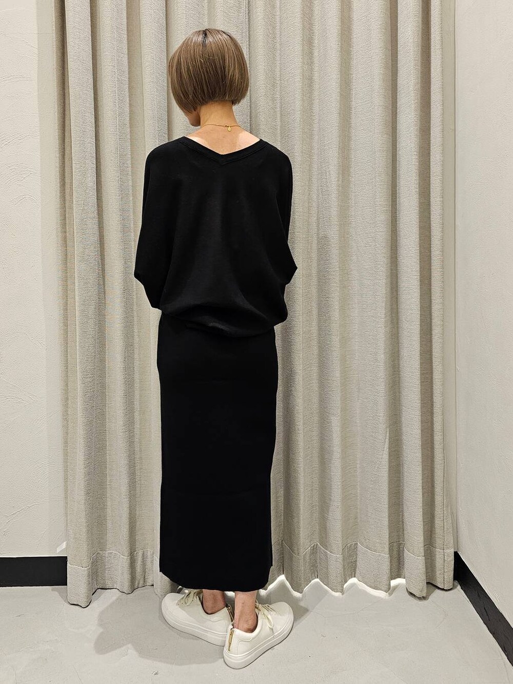 ブラック系のTシャツ/カットソー、ブラック系のスカート、ホワイト系のスニーカーを着用したレディースの冬コーディネートの4枚目の写真