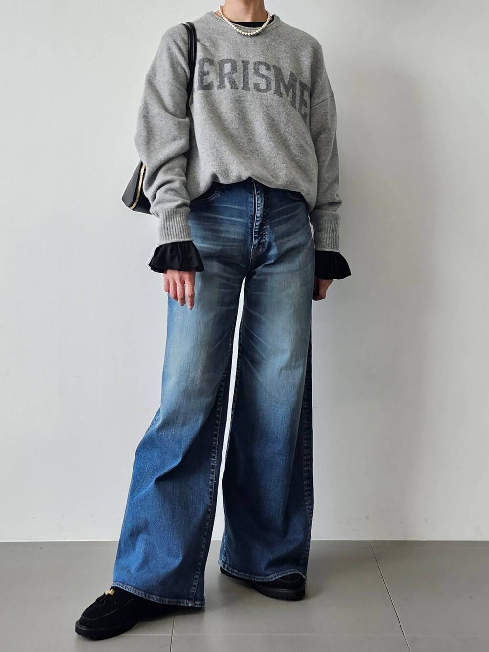 ブラック系のトートバッグ、ブラック系のTシャツ/カットソー、ブラック系のダウンジャケット/コートを着用したレディースの秋コーディネートの5枚目の写真