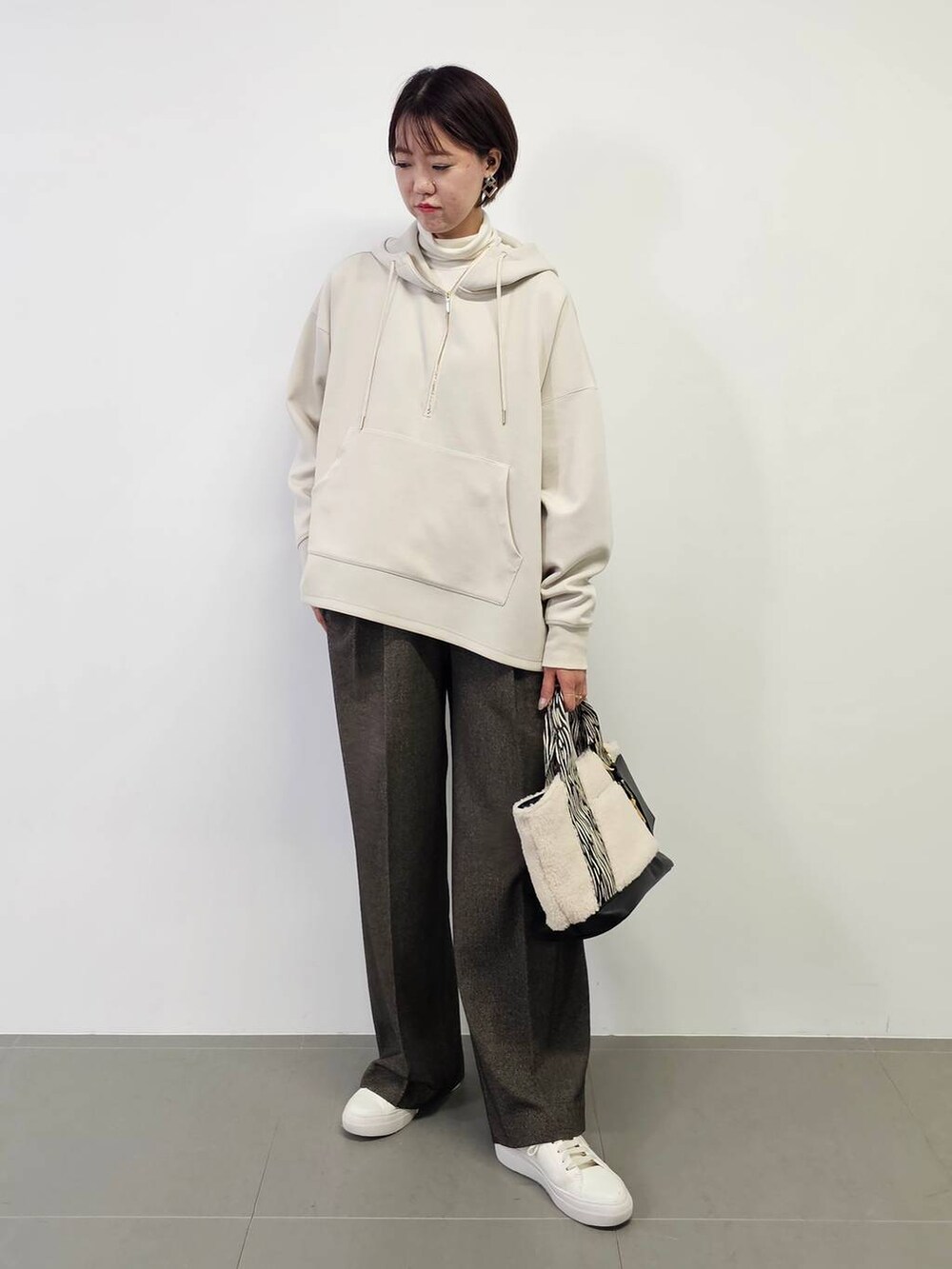 ホワイト系のTシャツ/カットソー、ホワイト系のスニーカー、ホワイト系のトートバッグを着用したレディースの冬コーディネートの5枚目の写真