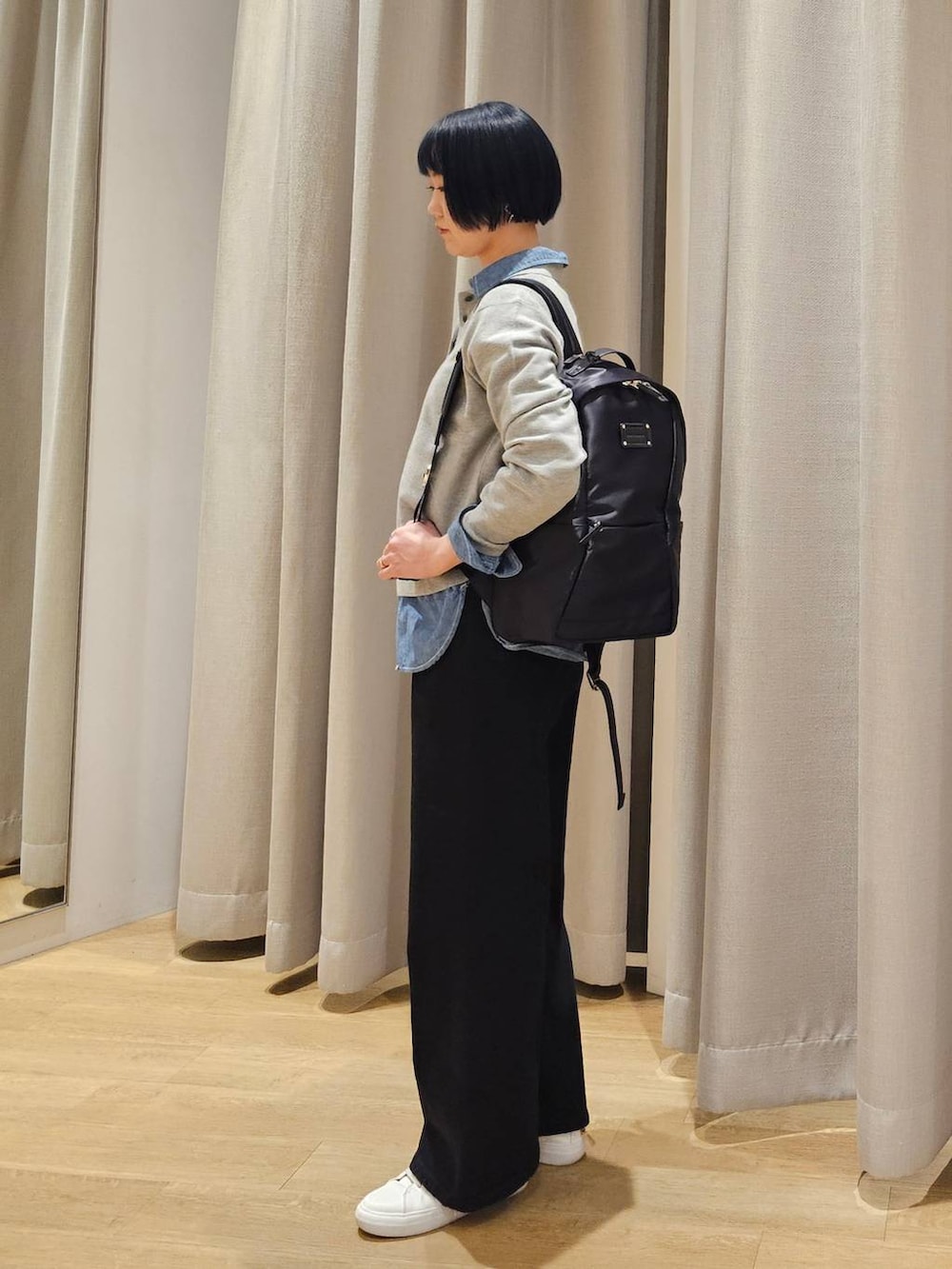 ブラック系のデニムパンツ、グレー系のニット/セーター、ブラック系のバックパック/リュックを着用したレディースの冬コーディネートの3枚目の写真