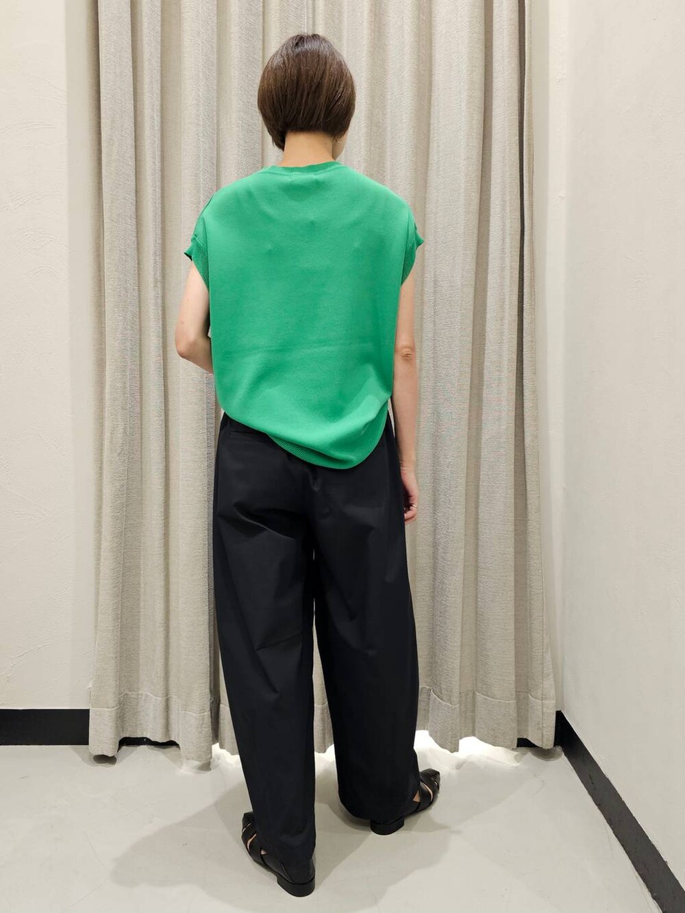 ブラック系のその他パンツ、ブラック系のパンプス、グリーン系のニット/セーターを着用したレディースの秋コーディネートの3枚目の写真