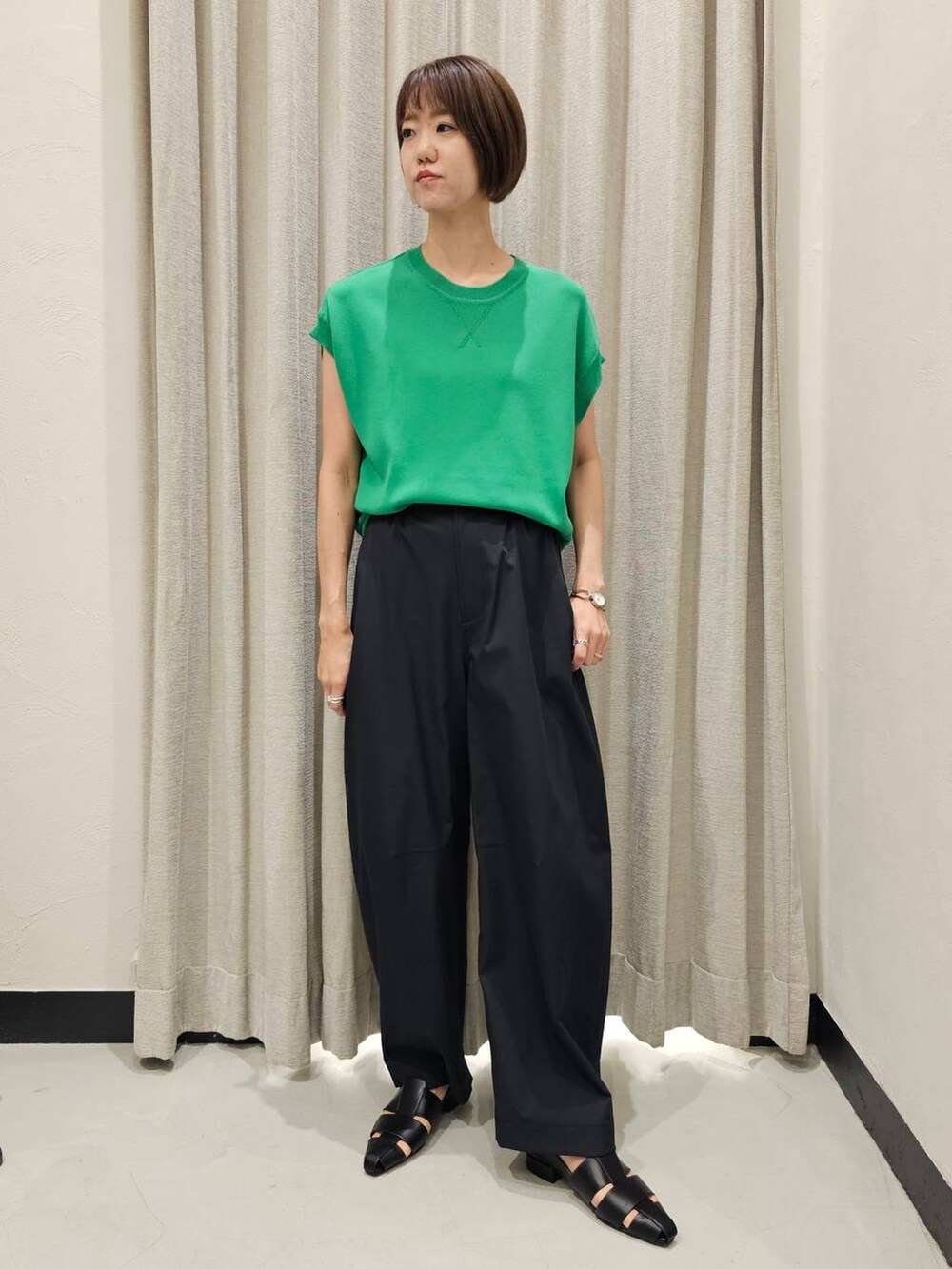 ブラック系のその他パンツ、ブラック系のパンプス、グリーン系のニット/セーターを着用したレディースの秋コーディネートの4枚目の写真