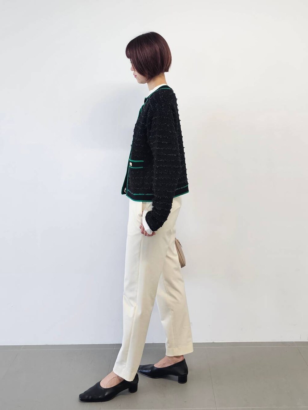 ベージュ系のボストンバッグ、ブラック系のパンプス、ホワイト系のその他パンツを着用したレディースの冬コーディネートの3枚目の写真