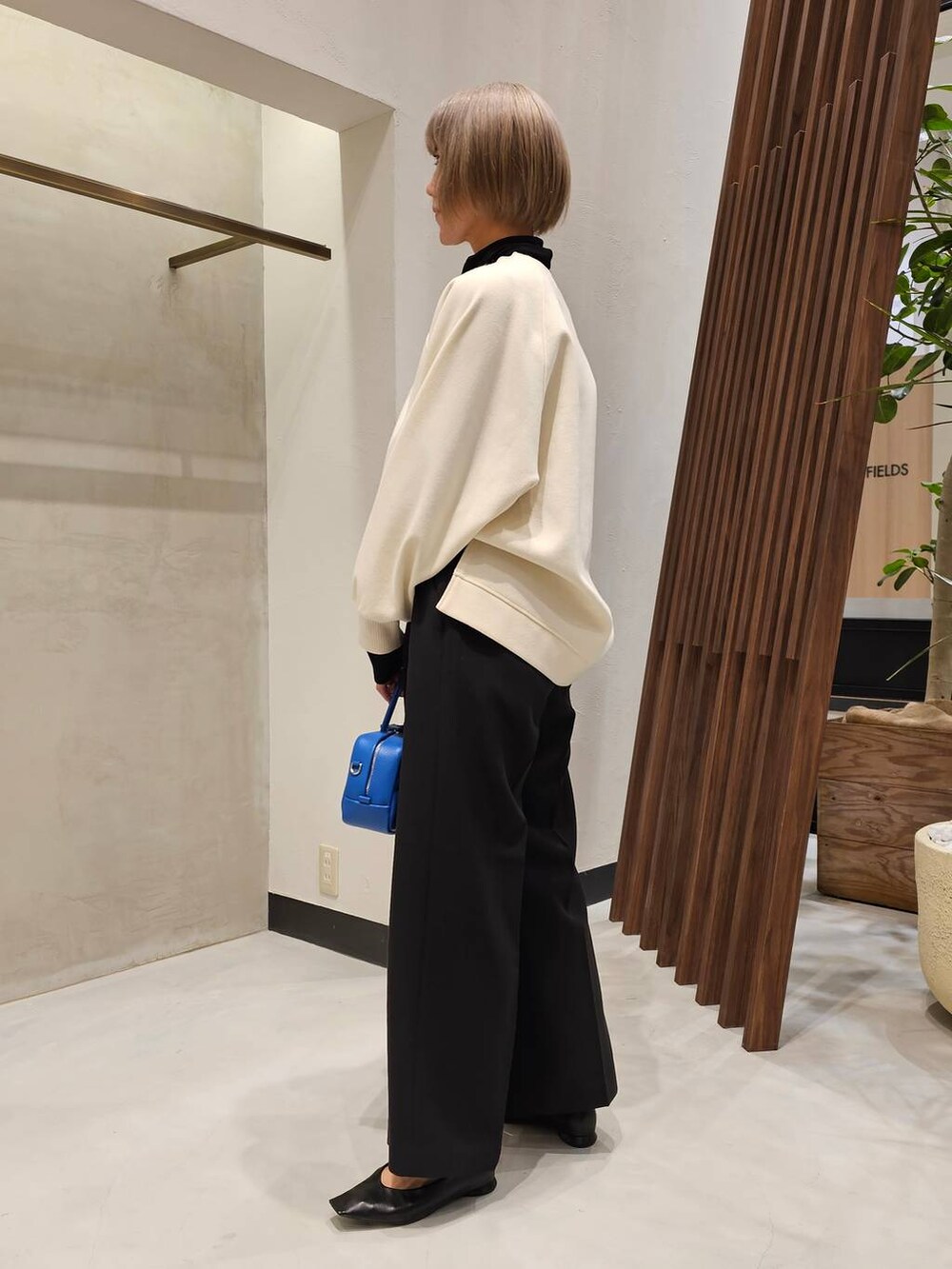 ブラック系のパンプス、ブラック系のTシャツ/カットソー、ホワイト系のニット/セーターを着用したレディースの冬コーディネートの4枚目の写真